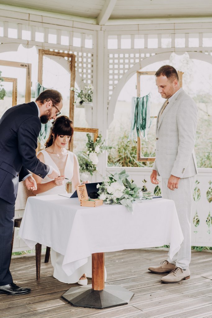 Ceremonia Humanistyczna Plenerowy ślub symboliczny para młoda składa podpis na akcie ślubnym Ceremonia Humanistyczna Plenerowy ślub symboliczny para młoda składa podpis na akcie ślubnym