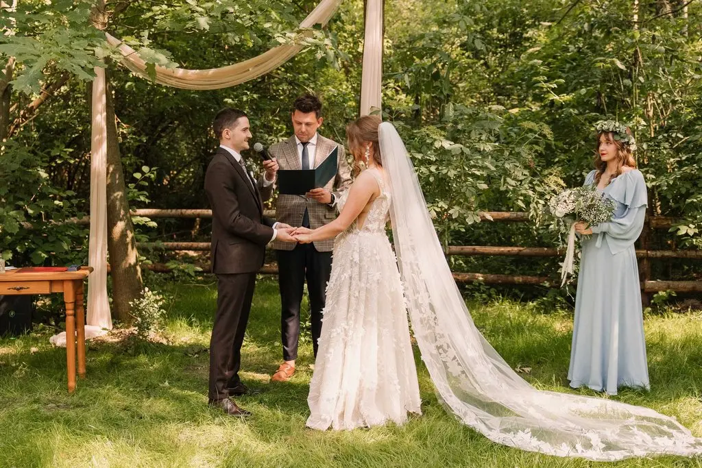 Pan młody składa przysięgę podczas kameralnej ceremonii plenerowej, ślub w stylu boho