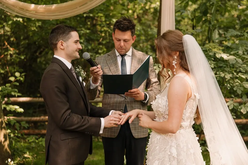 Pan młody składa przysięgę podczas kameralnej ceremonii plenerowej
