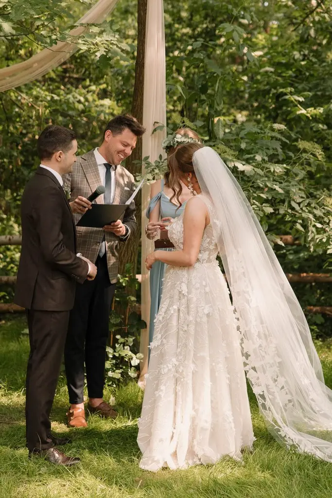 celebrans ślubu symbolicznego w trakcie ceremonii, ślub w leśnej scenerii