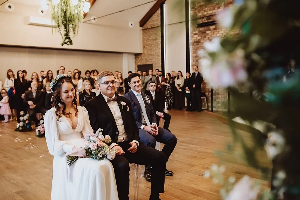 ślub cywilny na sali weselnej, para młoda i goście