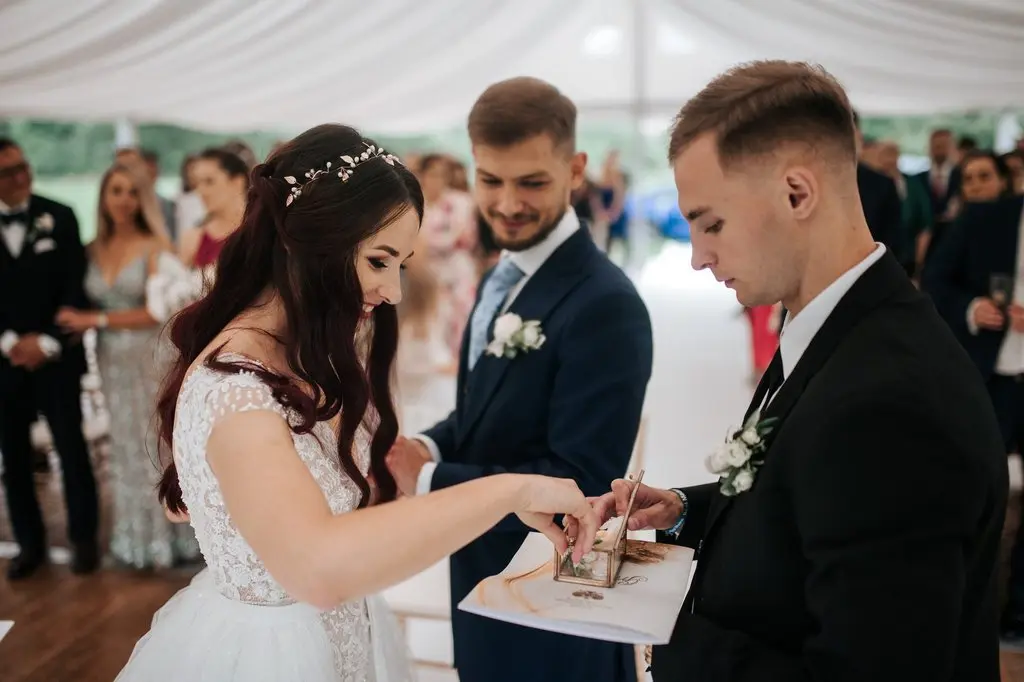 ślub pod namiotem, para młoda wymienia obrączki w trakcie ślubu humanistycznego